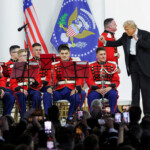 U.S. President Donald Trump gestures next to members of a band as he attends the Commander in Chief Ball in honor of his inauguration, along with first lady Melania Trump, in Washington, U.S., January 20, 2025. REUTERS/Daniel Cole
