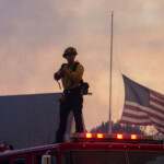 A member of a firefighting crew looks on from atop a firetruck as they work to battle the Hughes Fire near Castaic Lake, north of Santa Clarita, California, U.S. January 22, 2025. REUTERS/Ringo Chiu
