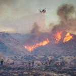 A helicopter drops water as the Hughes Fire burns in Castaic Lake, California, U.S. January 22, 2025. REUTERS/David Swanson