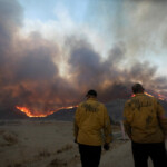 Members of a firefighting crew stand, as firefighters and aircraft battle the Hughes Fire near Castaic Lake, north of Santa Clarita, California, U.S. January 22, 2025. REUTERS/Ringo Chiu