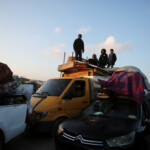 People stand on top of items placed in the back of a truck amid vehicles with Palestinians waiting to be allowed to return to their homes in northern Gaza by vehicle through Salahudeen road after they were displaced to the south at Israel's order during the war, amid a ceasefire between Israel and Hamas, in the central Gaza Strip, January 27, 2025. REUTERS/Hatem Khaled