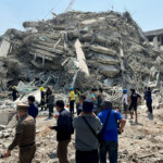 People stand near the site of a collapsed building after a strong earthquake struck central Myanmar on Friday, earthquake monitoring services said, which affected Bangkok as well with hundreds of people pouring out of buildings in the Thai capital in panic after the tremors, in Bangkok, Thailand, March 28, 2025. REUTERS/Ann Wang bangkok