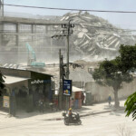 A person rides a scooter near the site of a collapsed building after a strong earthquake struck central Myanmar on Friday, earthquake monitoring services said, which affected Bangkok as well with hundreds of people pouring out of buildings in the Thai capital in panic after the tremors, in Bangkok, Thailand, March 28, 2025. REUTERS/Ann Wang