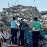 People stand near the site of a collapsed building after a strong earthquake struck central Myanmar on Friday, earthquake monitoring services said, which affected Bangkok as well with hundreds of people pouring out of buildings in the Thai capital in panic after the tremors, in Bangkok, Thailand, March 28, 2025. REUTERS/Ann Wang