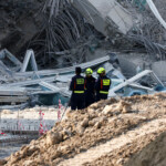 Rescue personnel stand near a building that collapsed after a strong earthquake struck central Myanmar on Friday, earthquake monitoring services said, which affected Bangkok as well with people pouring out of buildings in the Thai capital in panic after the tremors, in Bangkok, Thailand, March 28, 2025. REUTERS/Athit Perawongmetha