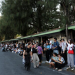 People wait at a bus stop after a strong earthquake struck central Myanmar on Friday, earthquake monitoring services said, which affected Bangkok as well with hundreds of people pouring out of buildings in the Thai capital in panic after the tremors, in Bangkok, Thailand, March 28, 2025. REUTERS/Chalinee Thirasupa