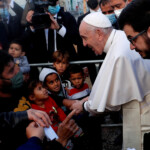 FILE PHOTO: Pope Francis reacts as he meets migrants during his visit to the Mavrovouni camp for refugees and migrants on the island of Lesbos, Greece, December 5, 2021. REUTERS/Guglielmo Mangiapane/File Photo