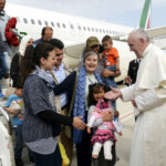 FILE PHOTO: Pope Francis welcomes a group of Syrian refugees after landing at Ciampino airport in Rome following a visit to the Moria refugee camp on the Greek island of Lesbos, April 16, 2016. Filippo Monteforte/Pool via REUTERS/File Photo