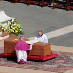 Clergy members touch Pope Francis' coffin, during his funeral Mass, in St. Peter's Square at the Vatican, April 26, 2025. REUTERS/Remo Casilli