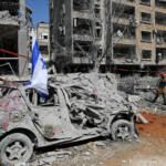 A rescue personnel walks next to a damaged vehicle at an impact site following missile attack from Iran on Israel, in Ramat Gan, Israel, June 14, 2025. REUTERS/Ronen Zvulun