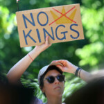 A demonstrator holds a sign to protest against U.S. President Donald Trump and his administration during a 'No Kings' rally near the U.S. embassy in Berlin, Germany, June 14, 2025. REUTERS/Fabrizio Bensch