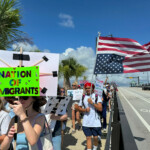 Protesters hold signs as they take part in a "No Kings" protest against U.S. President Donald Trump's presidency and immigration policies, near Mar-a-Lago, in West Palm Beach, Florida, U.S., June 14, 2025. REUTERS/Julien Pretot