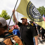 A member of Proud Boys holds a flag as he attends the "No Kings" rally near the Georgia State Capitol in Atlanta, Georgia, U.S., June 14, 2025. REUTERS/Alyssa Pointer