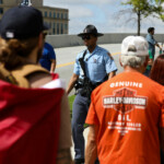 A Georgia State Patrol member walks near people on the day of the "No Kings" rally in Atlanta, Georgia, U.S., June 14, 2025. REUTERS/Alyssa Pointer