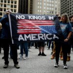 People hold a banner as they gather to attend the "No Kings" rally at the Daley Plaza in downtown Chicago, Illinois, U.S., June 14, 2025. REUTERS/Octavio Jones