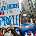 Adam Held, wearing a Captain America costume, holds a placard as people convene for the start of the "No Kings" rally at the Daley Plaza in downtown Chicago, Illinois, U.S., June 14, 2025. REUTERS/Octavio Jones