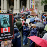 Demonstrators wear raincoats and use umbrellas as they gather during the "No Kings Day" protest against U.S. President Donald Trump's policies, in New York City, U.S., June 14, 2025. REUTERS/Eduardo Munoz