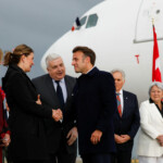 France's President Emmanuel Macron is greeted by Premier of Alberta Danielle Smith accompanied by Governor General of Canada Mary Simon, as world leaders arrive to meet in Kananaskis for the G7 leaders' summit, at Calgary International Airport in Calgary, Alberta, Canada June 15, 2025. REUTERS/Amber Bracken/Pool