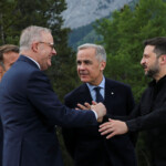 Canadian Prime Minister Mark Carney and French President Emmanuel Macron look on as Australian Prime Minister Anthony Albanese and Ukraine's President Volodymyr Zelenskiy embrace each other as they pose for a photo during the G7 Leaders' Summit in Kananaskis, in Alberta, Canada, June 17, 2025. REUTERS/Amber Bracken