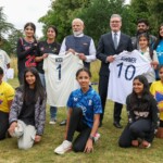 Britain's Prime Minister Keir Starmer looks on as Prime Minister Narendra Modi holds a Cricket bat, signed by Indian Cricket players, as they meet school children at Chequers near Aylesbury, England