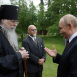 Russian President Vladimir Putin talks to Archbishop Alexei of Sitka and Alaska after a ceremony to lay flowers at the graves of Soviet soldiers at Fort Richardson National Cemetery near Anchorage, Alaska, U.S., August 15, 2025. Sputnik/Gavriil Grigorov/Pool via REUTERS