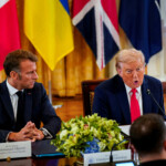 French President Emmanuel Macron speaks to U.S. President Donald Trump during a meeting with Ukrainian President Volodymyr Zelenskiy (not pictured) and European leaders amid negotiations to end the Russian war in Ukraine, at the White House in Washington, D.C., U.S., August 18, 2025. REUTERS/Al Drago
