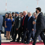 Israeli Prime Minister Benjamin Netanyahu walks with U.S. President Donald Trump and Israeli President Isaac Herzog at Ben Gurion International Airport, amid a U.S.-brokered prisoner-hostage swap and ceasefire deal between Israel and Hamas, in Lod, Israel, October 13, 2025. REUTERS/Evelyn Hockstein