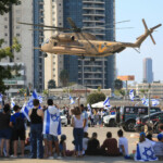 People watch a helicopter, on the day of hostages-prisoners swap, during a ceasefire deal in Gaza between Hamas and Israel, at Rabin Medical Center-Beilinson Hospital, in Petah Tikva, Israel October 13, 2025. REUTERS/Itay Cohen