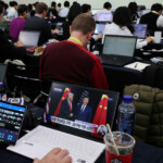 A member of the media watches a news broadcast of the meeting between U.S. President Donald Trump and Chinese President Xi Jinping on the sidelines of the Asia-Pacific Economic Cooperation (APEC) summit, at the media center for the APEC summit, in Gyeongju, South Korea, October 30, 2025.   REUTERS/Kim Hong-Ji