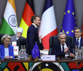 France's President Emmanuel Macron walks past European Commission President Ursula von der Leyen and Canada's Prime Minister Mark Carney during a plenary session on the first day of the G20 Leaders' Summit at the Nasrec Expo Centre in Johannesburg, South Africa, November 22, 2025. REUTERS/Yves Herman