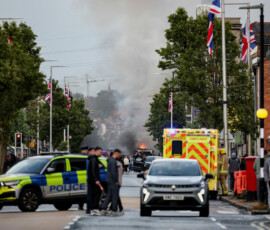 Law enforcement operates as smoke billows from a burning vehicle during a protest after a knife attack on June 8 left a man seriously injured and prompted police to declare a critical incident, on Newtownards Road in Belfast, Northern Ireland, June 9, 2026. REUTERS/Isabel Infantes TPX IMAGES OF THE DAY