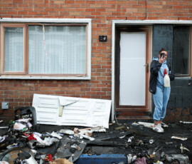 A resident takes pictures of debris on a street in the neighbourhood, in the aftermath of anti-immigrant protests following a knife attack on June 8, which left a man seriously injured and prompted police to declare a critical incident, at Lendrick Street, east Belfast, Northern Ireland, June 10, 2026. REUTERS/Isabel Infantes