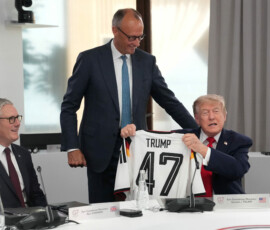German Chancellor Friedrich Merz presents U.S. President Donald Trump, with a jersey with the number 47 on it as British Prime Minister Keir Starmer looks on during a working session at the G7 summit in Evian-les-Bains, France, June 16, 2026. Thibault Camus/Pool via REUTERS