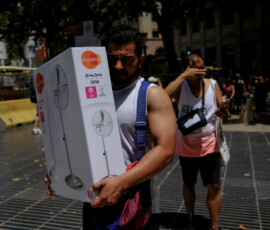 A man carries a newly purchased fan as temperatures rise, during a heatwave affecting a large part of Spain, in Barcelona, in Spain, June 21, 2026. REUTERS/Nacho Doce