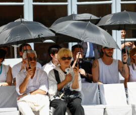 People shield themselves with umbrellas from the sun during Thom Browne’s Spring/Summer 2027 men’s collection show as part of Milan Fashion Week, in Milan, Italy, June 22, 2026. REUTERS/Alessandro Garofalo