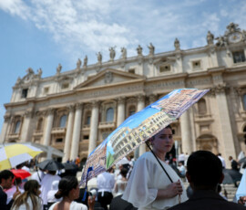 A woman shelters herself from the sun under an umbrella on the day Pope Leo holds the weekly general audience in St. Peter's Square at the Vatican, June 24, 2026. REUTERS/Yara Nardi