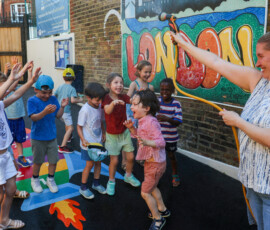 A teacher sprays water on pupils to cool them at L'Ecole des Petits, an independent French bilingual school, as Britain experiences record temperatures during a heatwave in Fulham, London, Britain, June 24, 2026. REUTERS/Kevin Coombs