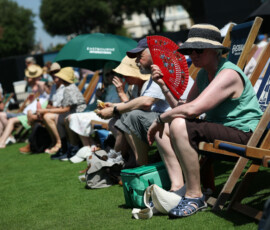 Tennis - Eastbourne Open - Devonshire Park Lawn Tennis Club, Eastbourne, Britain - June 24, 2026 General view of a spectator on the outside courts as she uses a hand fan amidst the heatwave REUTERS/Isabel Infantes