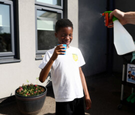 A pupil is sprayed with a fine mist as they drink water at the Harris Academy Primary Maxyflower school, as Britain experiences record temperatures disrupting schools and transport networks, in Grays, Britain, June 24, 2026. REUTERS/Jack Taylor TPX IMAGES OF THE DAY