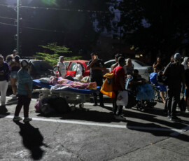 People stand next to patients in wheelchairs and hospital beds on the street outside a hospital after an earthquake, in Caracas, Venezuela, June 24, 2026. REUTERS/Leonardo Fernandez Viloria