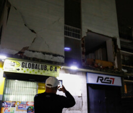 A person uses a cellphone to make video of a damaged building after an earthquake, in Caracas, Venezuela, June 24, 2026. REUTERS/Fausto Torrealba