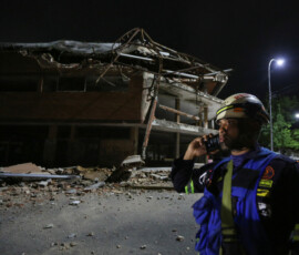 A firefighter stands next to a damaged building that used to house a university several years ago, after a strong earthquake, in Valencia, Venezuela, June 24, 2026. REUTERS/Juan Carlos Hernandez