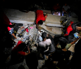 People gather as emergency workers and residents search for victims after earthquakes, in La Guaira, Venezuela, June 25, 2026. REUTERS/Maxwell Briceno