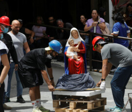People transport a religious statue of the Madonna and Child near the site of a damaged building after earthquakes hit the country, in Caracas, Venezuela, June 25, 2026. REUTERS/Fausto Torrealba
