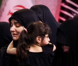 A woman carrying a child reacts near the coffins of Iran's late Supreme Leader Ayatollah Ali Khamenei and his family members, as international delegates participate in a farewell ceremony for Khamenei, who was killed on February 28 during Israeli and U.S. airstrikes on Iran, at the Imam Khomeini Grand Mosalla in Tehran, Iran July 3, 2026. Majid Asgaripour/WANA (West Asia News Agency) via REUTERS ATTENTION EDITORS - THIS PICTURE WAS PROVIDED BY A THIRD PARTY. ISRAEL OUT. NO COMMERCIAL OR EDITORIAL SALES IN ISRAEL. NO ACCESS FOR ISRAELI MEDIA. NO USE BBC PERSIAN. NO USE VOA PERSIAN. NO USE MANOTO. NO USE IRAN INTERNATIONAL. NO USE RADIO FARDA. DIGITAL: NO USE BBC PERSIAN. NO USE VOA PERSIAN. NO USE MANOTO. NO USE IRAN INTERNATIONAL. NO USE RADIO FARDA.