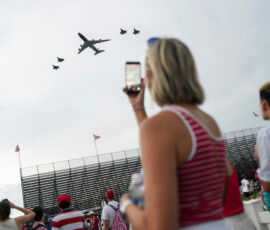 A woman takes a video as Air Force One flies over the National Mall, as part of Fourth of July celebrations marking the 250th anniversary of U.S. Independence, in Washington, D.C., U.S., July 4, 2026. REUTERS/Nathan Howard