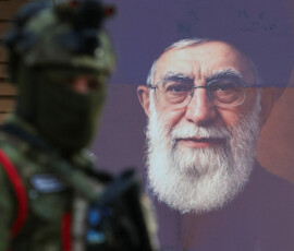 An Iraqi police officer stands guard in front of a banner bearing a portrait of Iran's late Supreme Leader Ayatollah Ali Khamenei ahead of funeral processions in Najaf and Karbala, in Najaf, Iraq, July 6, 2026. REUTERS/Alaa Al-Marjani
