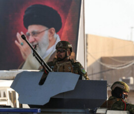 Iraqi police officers sit in an armored vehicle near a banner bearing a portrait of Iran's late Supreme Leader Ayatollah Ali Khamenei ahead of funeral processions in Najaf and Karbala, in Najaf, Iraq, July 6, 2026. REUTERS/Alaa Al-Marjani