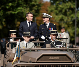 French President Emmanuel Macron stands in the command car with General Chief of Staff of the French Armed Forces Fabien Mandon during the annual Bastille Day military parade on the Champs-Elysees avenue in Paris, France, July 14, 2026. REUTERS/Benoit Tessier/Pool