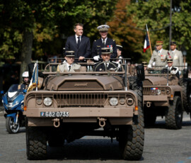 French President Emmanuel Macron stands in the command car with General Chief of Staff of the French Armed Forces Fabien Mandon during the annual Bastille Day military parade on the Champs-Elysees avenue in Paris, France, July 14, 2026. REUTERS/Benoit Tessier/Pool
